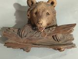 carvings of a bear on a piece of wood on a table