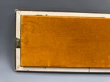 Une vieille valise doublée de velours jaune est posée sur une table