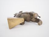 brass figurine of an elephant laying on its back with a triangle on its back