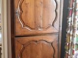 a tall wooden cabinet in the corner of a room
