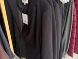 clothes hanging on a rack in a clothing store with clothes on hangers