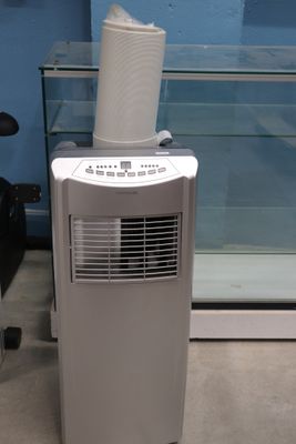 un petit climatiseur posé par terre devant une vitrine