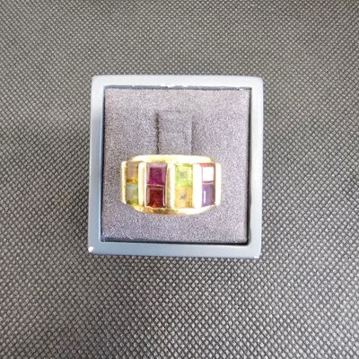 bague en or jaune sertie de pierres multicolores, présentée dans un coffret cadeau