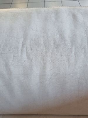 un rouleau de tissu blanc posé par terre, à côté d'un sol carrelé
