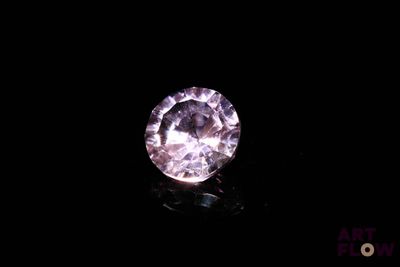 a close up of a pink diamond on a black surface