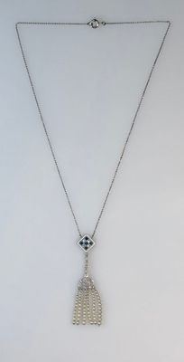a white necklace with a silver chain and a pendant with an evil eye on it