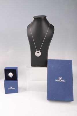 trois colliers et une bague exposés sur une table