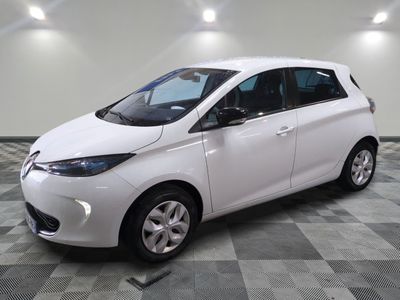 une voiture blanche garée dans une pièce au sol en damier