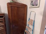une échelle appuyée contre le mur, à côté d'une armoire