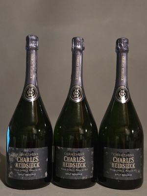 trois bouteilles de champagne posées sur une table l'une à côté de l'autre