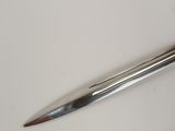 a metal pen that is laying on a white surface