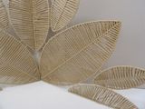 a wicker sculpture of a large leaf on a white surface