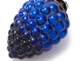 a close up of a blue blackberry on a white surface