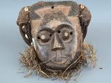une image représentant un masque en bois sur lequel se trouve un nid d'oiseau