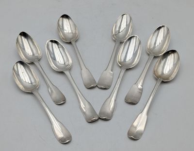 six silver spoons are arranged in a circle on a table