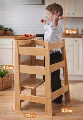 a young boy that is standing in a high chair