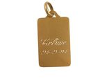 a gold plated charm with a small square tag on it