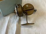 a small fishing reel and a box on a bed