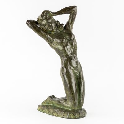 une statue en bronze représentant une femme tenant sa tête entre ses mains