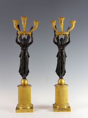 paire de bougeoirs anciens en bronze sur des socles en marbre