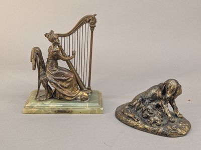 une statue représentant une femme jouant de la harpe, à côté d'une statue représentant un chien