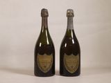 two bottles of champagne sitting next to each other on a white surface
