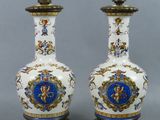 deux vases blancs et bleus posés sur une table, à côté d'une lampe