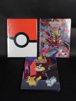 Deux livres sur les Pokémon sont posés l'un à côté de l'autre sur une surface noire