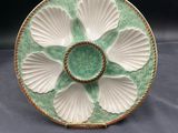 a close up of a green and white plate with a flower on it