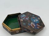 a small box with a lid that has a flower design on it