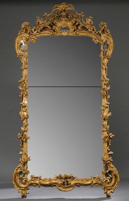 un miroir richement sculpté, avec un cadre doré sur fond gris