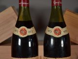 pair of bottles of wine sitting on top of a wooden crate