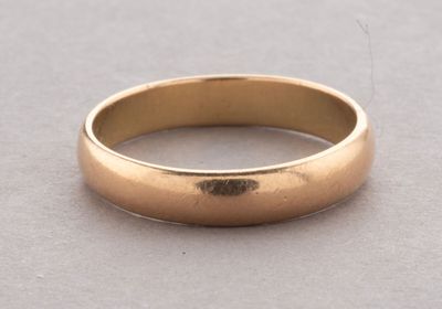 a close up of a gold wedding ring on a table