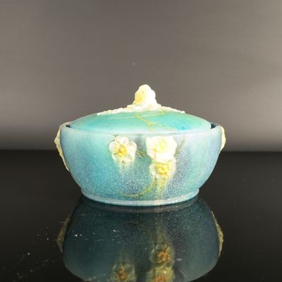 a blue bowl with yellow flowers on it sitting on a table