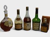 several bottles of liquor are lined up in a row on a white surface