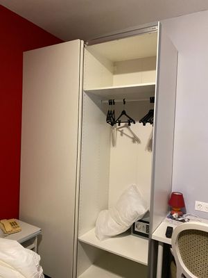 a bedroom with a bed, desk, and closet in it