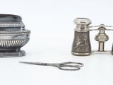pair of antique silver salt and pepper shakers next to a pair of scissors