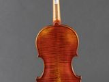 an old violin on a stand against a gray background