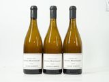 trois bouteilles de vin posées sur une table blanche