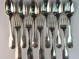 a lot of silver spoons and spoons on the table