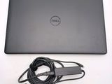 dell laptop computer with power cord and charger sitting on a white surface