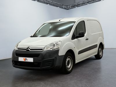 La camionnette blanche est garée dans une grande pièce blanche.