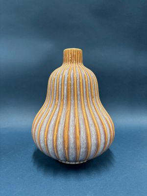 yellow and white striped vase sitting on a blue surface