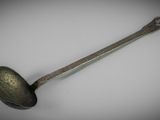 a close up of a spoon with a handle on a white surface