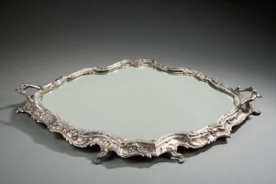 un plateau en argent richement décoré, orné d'un miroir en son centre