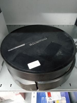 une casserole noire posée dans un micro-ondes, sur un plan de travail