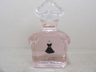 un flacon rose orné d'une robe noire