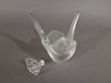 a clear glass bird sitting on a table next to a crystal heart