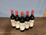 four bottles of wine are lined up on a wooden table