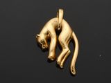 an image of a gold cat charm on a black surface